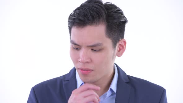 Face of Stressed Young Asian Businessman Thinking and Looking Down