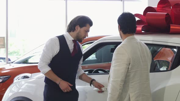 Professional Car Salesman Opening Door of a Car for His Male Customer