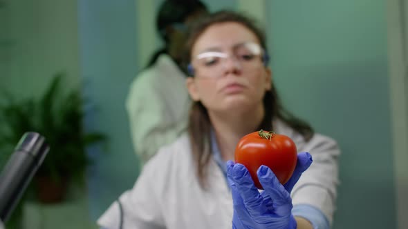 Front View of Biologist Reseacher Woman Analyzing Pepper Injected with Chemical Dna