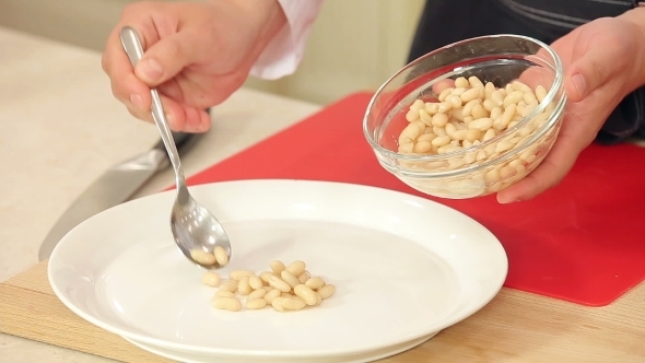Chef Putting White Beans On a Plate For a Salad