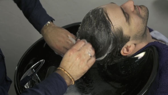 Man Washing Hair With Shampoo In Salon