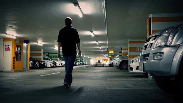 Man Walks To Car In Parking Garage