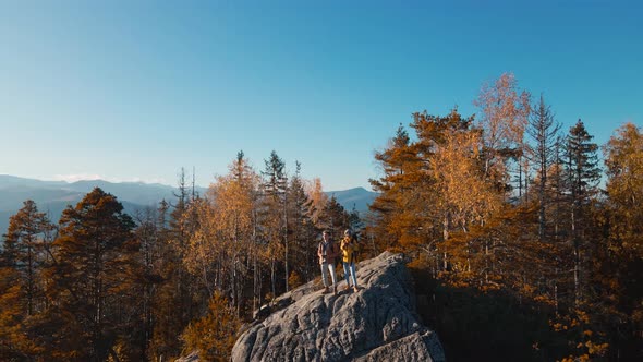 Aerial Footage Couple Hikers Standing on Top of Cliff Making Drone Selfie