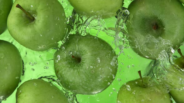 Super Slow Motion Shot of Fresh Green Apple Falling and Splashing Into Water at 1000Fps alt
