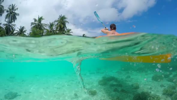 Water shot of a man kayaking around a tropical island.