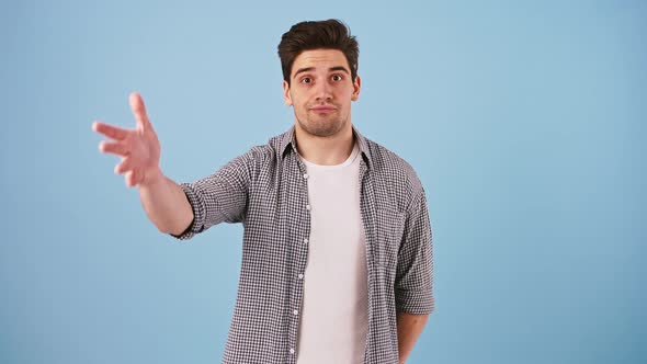 Young Man in Casual Outfit is Looking Disappointed and Showing Facepalm Gesture While Posing on Blue