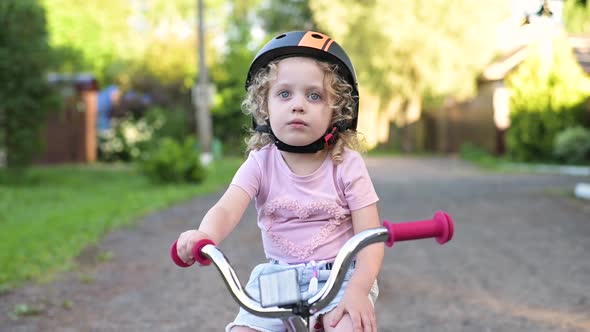 Portrait of a little girl in a bicycle helmet with a bicycle