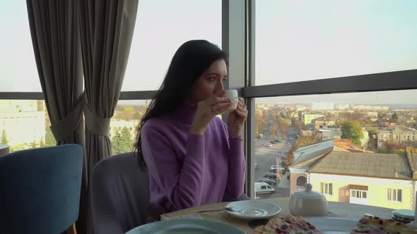 Girl Drinks Coffee In Cafe