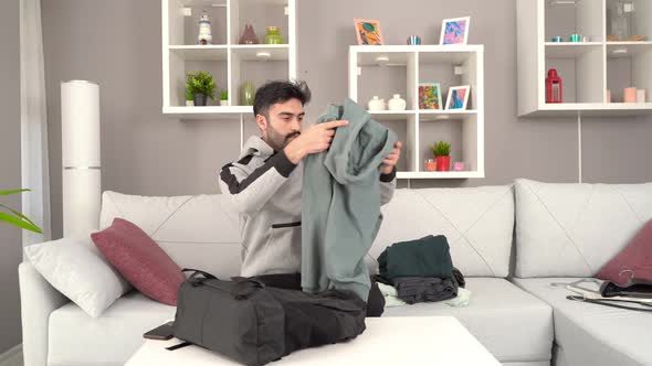 Man takes his clothes out of his bag.