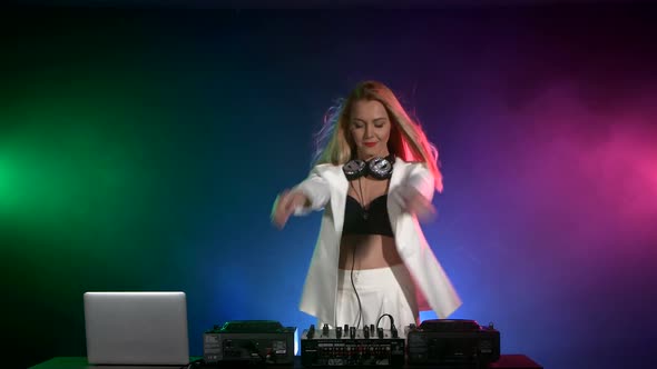 Beautiful, Smiling, Sexy Dj Girl in White Jacket, Headphones Playing Music and Dancing, Hand in the