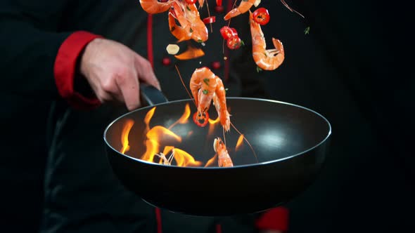 Super Slow Motion Shot of Chef Holding Frying Pan and Falling Shrimps Into Fire at 1000Fps.