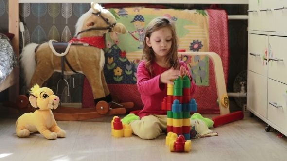 Cute Little Girl Playing With Toy Blocks At Home