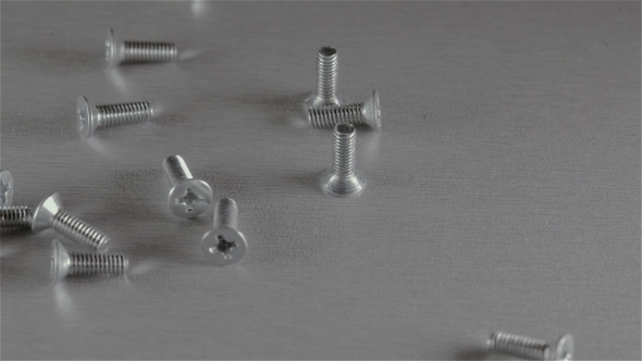 Many Short Screws Scattered On The Gray Surface