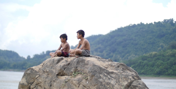 Two Asian Kids Sitting On The Rock