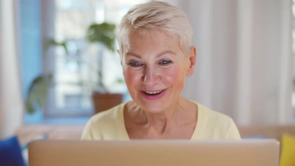Excited Older Woman Looking at Laptop Screen Rejoicing Winning Lottery
