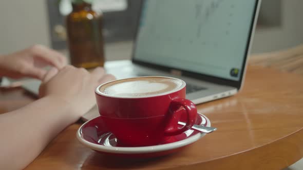 Using Laptop With A Cup Of Coffee