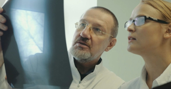 Two Doctors Discussing An X-Ray Picture alt