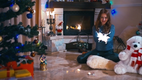 Girl Sitting Near a Fireplace With Sparklers alt