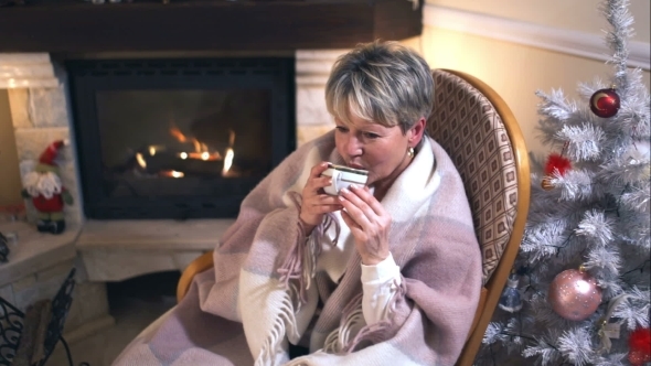 Mature Woman Drinking Coffee In a Cozy Living Room