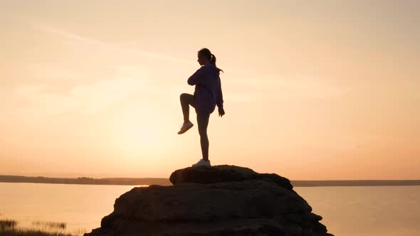 A Girl Does Fitness on a Hill at Sunset