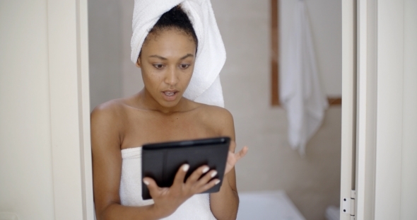 Woman Wearing Bath Towel Using Tablet Computer