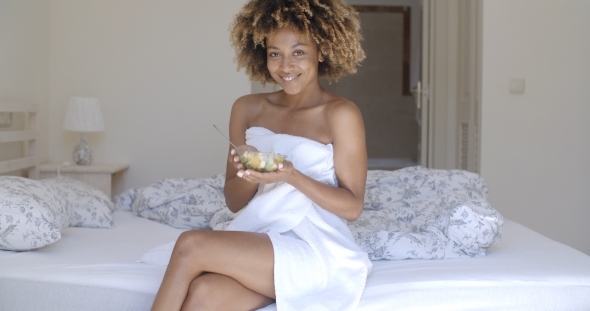 Young Woman On Bed Eating Vegetable Salad