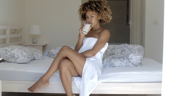 Pretty Girl Drinking Milk On The Bed