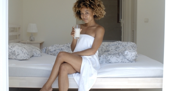 Pretty Girl Drinking Milk On The Bed