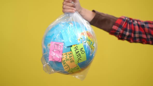 Closeup Earth Globe in Plastic Bag with Adhesive Notes Showing Ecology Problems