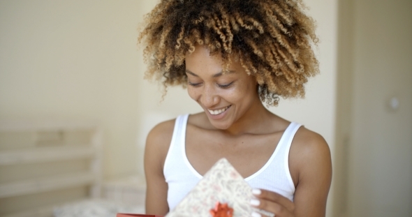 Happy Young Woman Open Gift Box In Bedroom