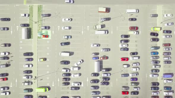 A bird's-eye view of parked cars in the parking lot near the shopping center.