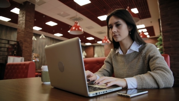 Woman Working On Modern Laptop In Cafe