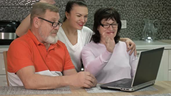 An Elderly Couple and Their Adult Daughter Are Communicating with Someone Via the Internet