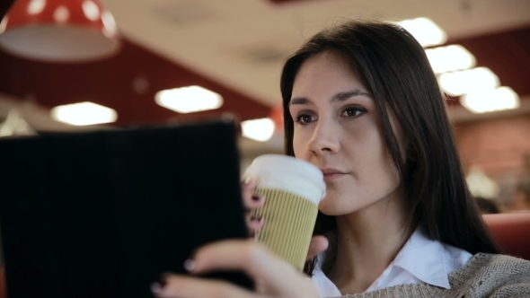 Woman Using Tablet Computer Touchscreen In Cafe 