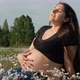Young Pregnant Woman Sitting in a Flower Field - VideoHive Item for Sale