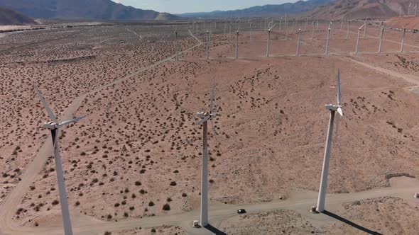 4K Drone circles windmill spinning in high desert of california