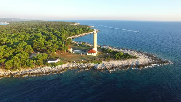 Flying over lighthouse, Croatia with a motorboat passing by