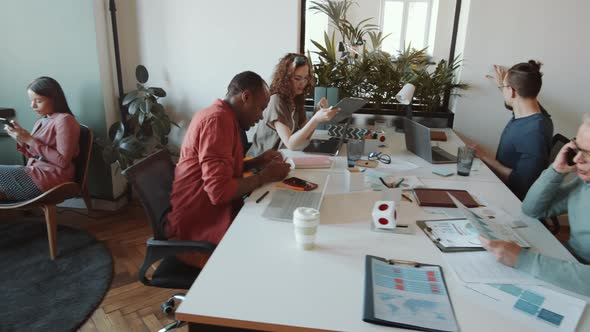 Diverse Colleagues Working Together at Table in Office