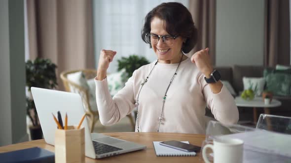 Beautiful Elderly Woman Joy and Say Yes, Sitting Front of Laptop in Home Room