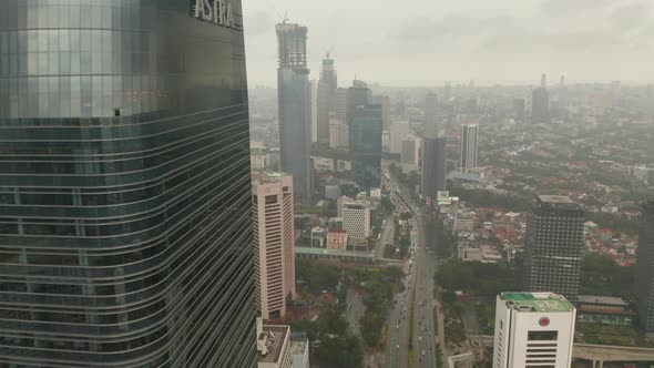 Aerial View Reveal Flying From Behind a Skyscraper To Wide View of Jakarta City Skyline Reveal 
