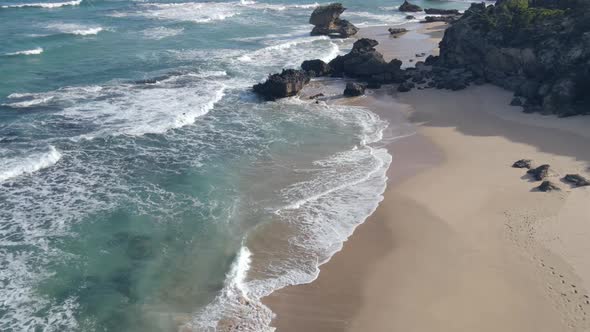 Drone Stationary in Sky As Waves Roll Into Shore