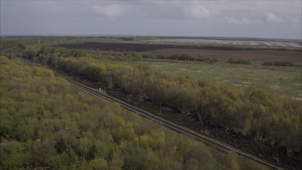 A Railway Track Passing Through the Forest and Field