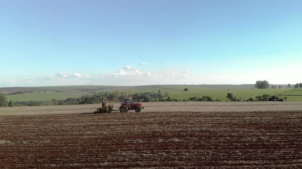 Tractor with seeder in the field. Sowing of corn, Maize in soil, with pneumatic sowing machine durin