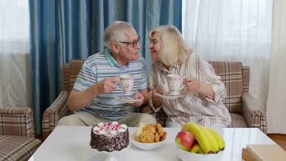 Mature Family Couple Grandfather Grandmother Relaxing on Cozy Sofa Enjoying Conversation at Home