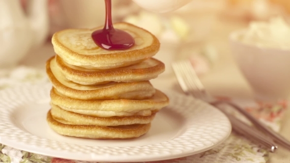 Stack Of Home-cooked Pancakes With Pouring Jam