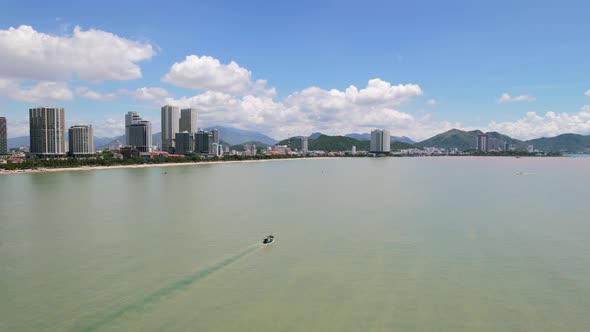 aerial drone circling a fishing boat motoring in the murky turquoise green ocean sea of Nha Trang Vi