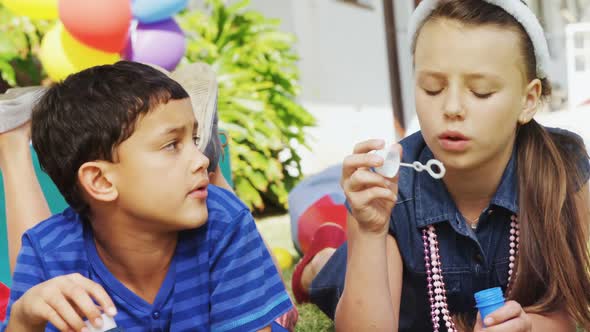 Happy friends playing with bubble wand in backyard 4k