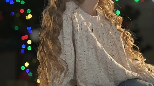 Little Girl Dreaming About X-Mas Gift, Sitting Against Illuminated Background