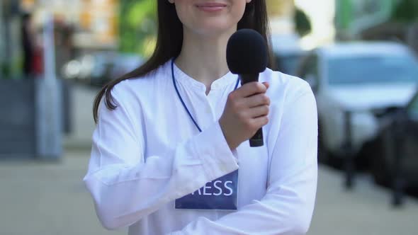 Smiling Female Journalist With Press Pass Folding Arms Holding Microphone, Media