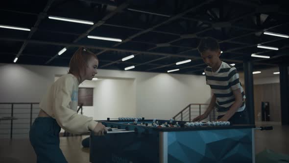 Excited Students Playing Table Football in Empty School Lobby After Classes